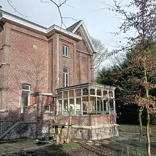Historische woning in Sas van Gent vóór renovatie met karakteristiek metselwerk en serre