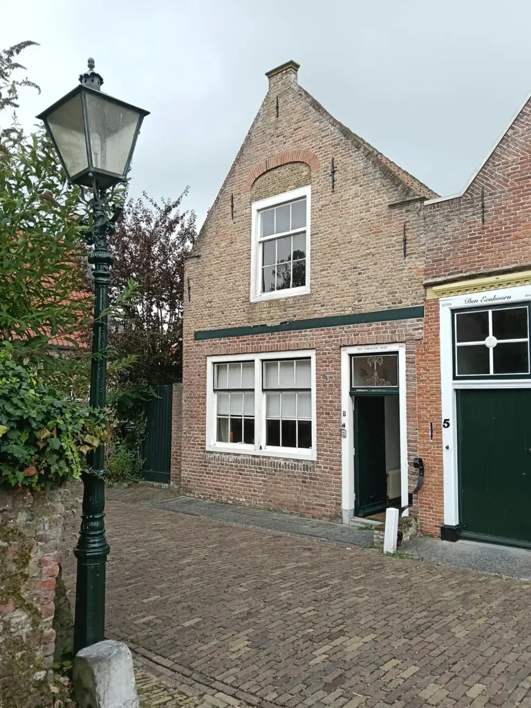 Historische woning in Sas van Gent vóór renovatie met karakteristiek metselwerk en serre